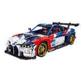 Vue 3/4 avant de la BMW M4 GT3 en briques livrée tricolore bleu rouge blanc avec jantes dorées